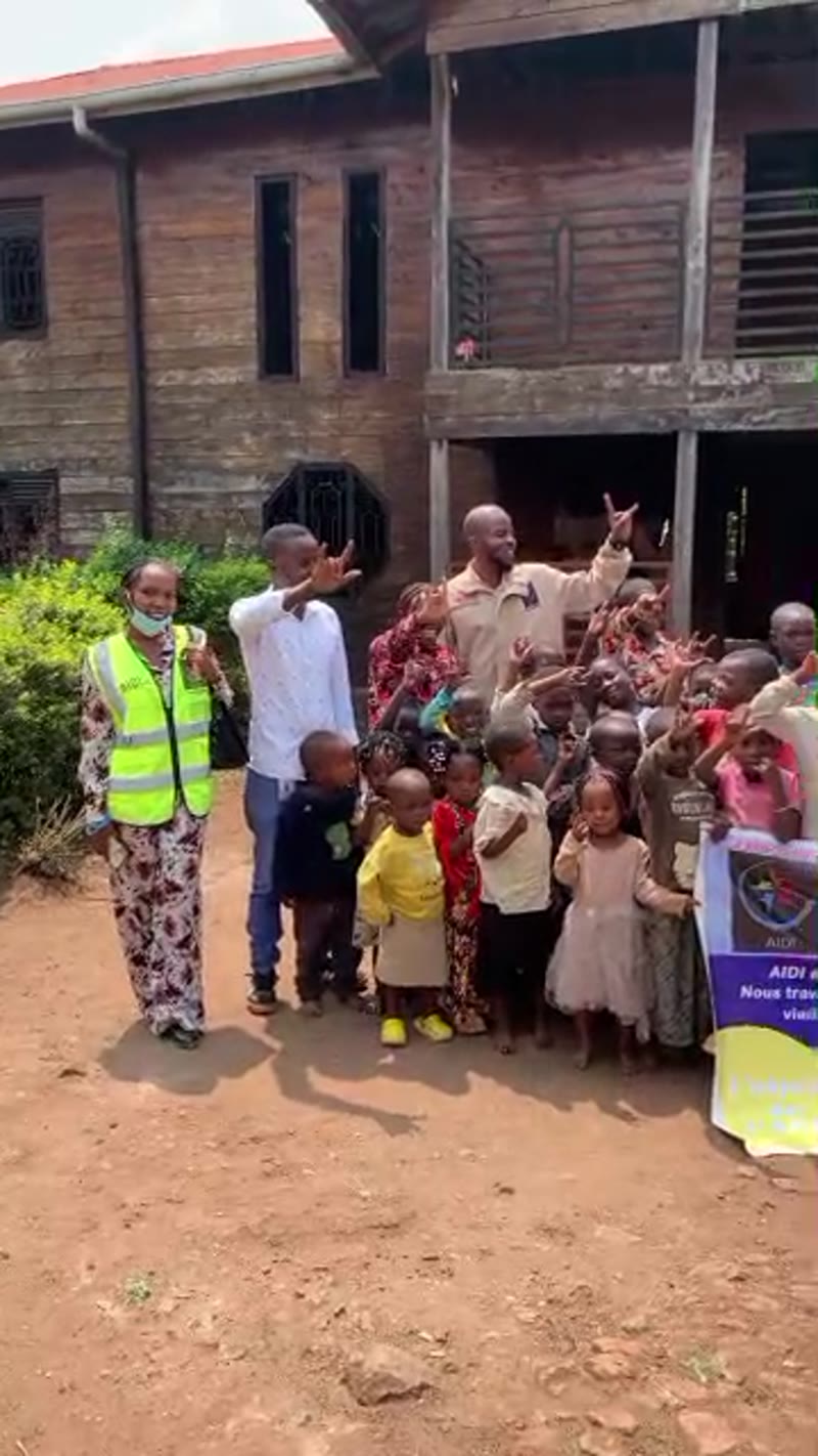 Charles et les enfants sourds font le signe I love you en langue des signes